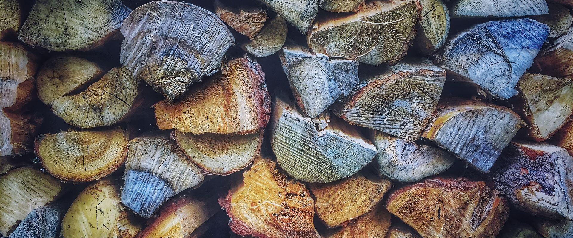 Textural photograph of a stack of wood pictured from the side, Source Unsplash 68360